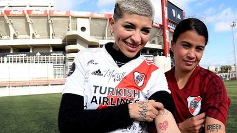 Cazzu junto a Carolina Birizamberri, ambas muestran sus tatuajes riverplatenses.
